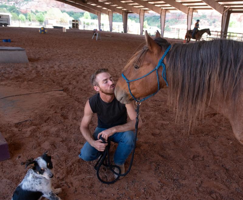 Equine trainer Christian Mathews kissing the nose of Byron the horse