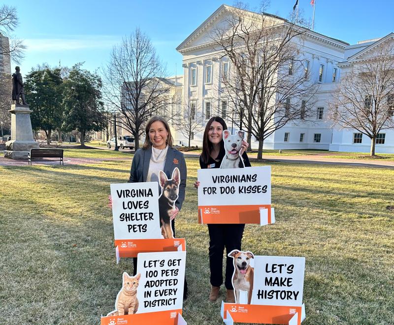 Two people with signs outside the Capitol in Richmond, Virginia