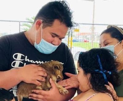 Family of three all looking (and holding) a puppy