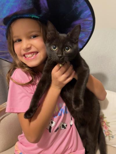 A smiling child holding Lucky the kitten