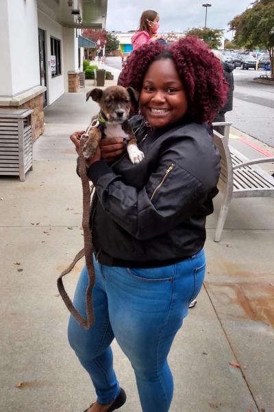 Smiling person holding Marvin the puppy