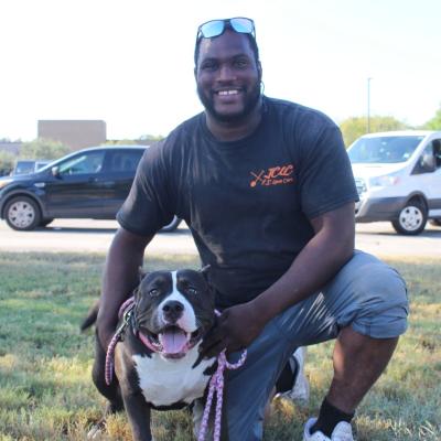 Person beside a happy black and white dog