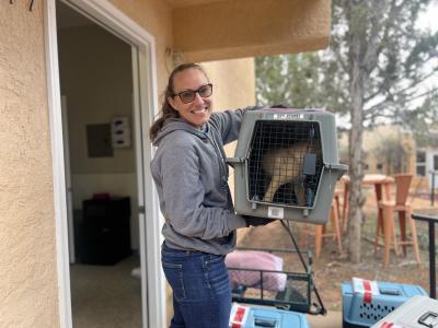 Amy Kohlbecker holding a carrier containing a puppy