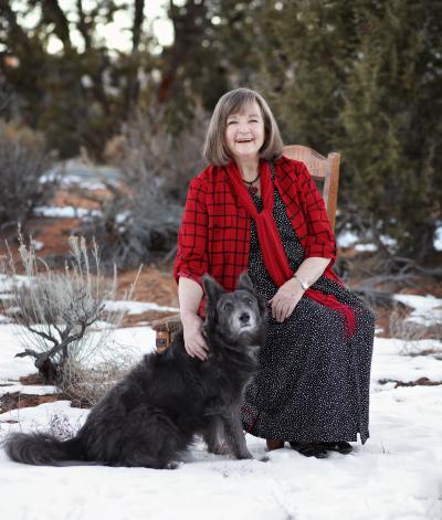 Faith Maloney sitting outside with a dog with snow on the ground