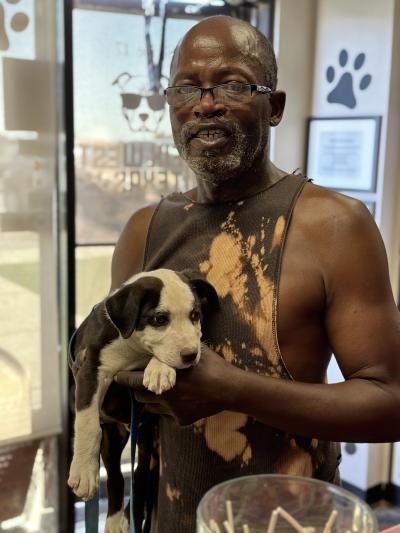 Peron holding a black and white puppy