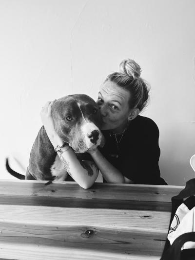 Black and white photo of person kissing Bear the dog with her arms wrapped around him