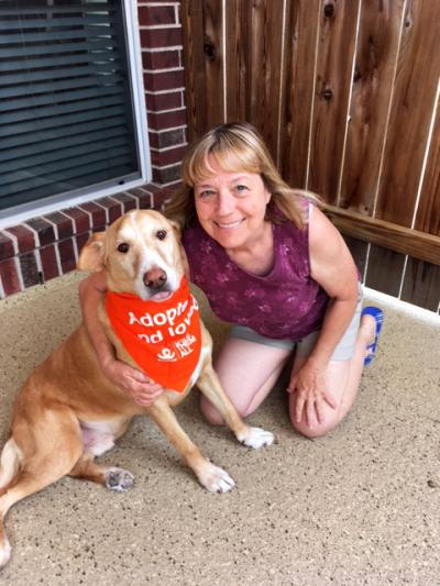 Nanci with Fergus the dog wearing a bandanna