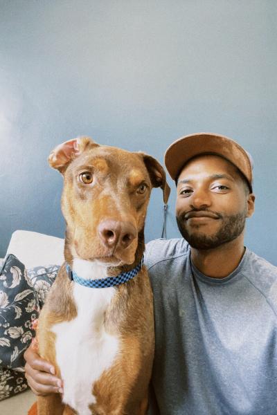 Smiling person with hand around hugging Vera the dog