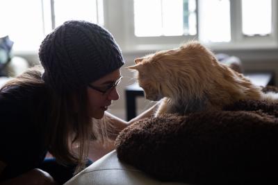 Silhouette of Cinna the cat and Alida with a window behind them