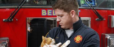 Fire engineer Jordan Lide holds Flame who is taken care of by the Belmont Fire Department in Greenville, SC