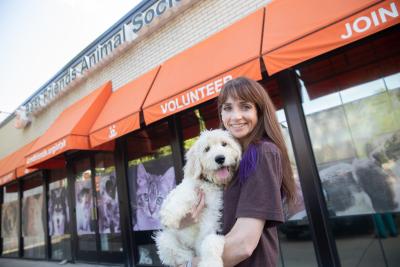 Person holding a dog in front of the Pet Lifesaving Center in Salt Lake City