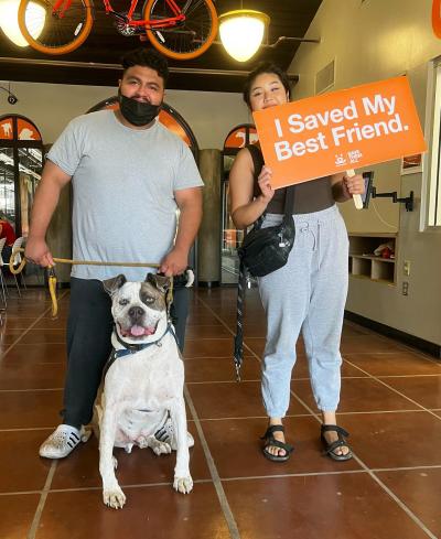 Jose Ramirez with Hulk the dog and another person holding a sign that says, 'I saved my best friend'