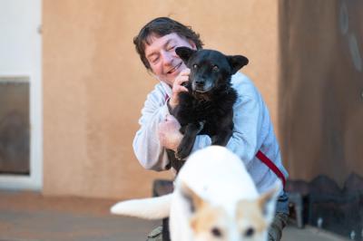 Caregiver Tom holding Hannah the dog with Elton in the foreground