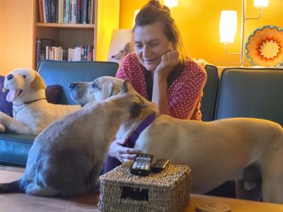 Nancy sitting on a couch with Yogi the dog and Pong the cat