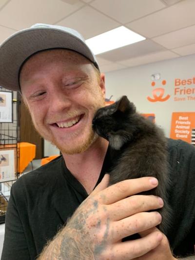 Smiling person holding Cleopatra the little kitten