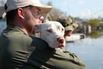 Jeff holding a white dog rescued following Hurricane Katrina