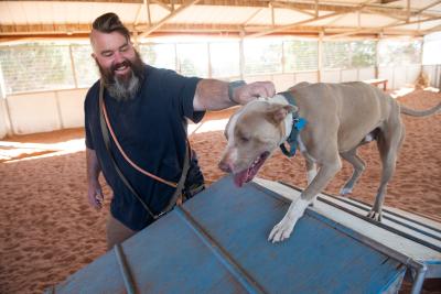 James at an agility course with Bonito the dog, who is going up over a ramp