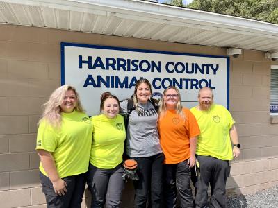 Group of five people in front of the Harrison County Animal Control sign