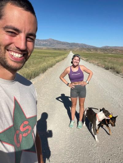 Noël and Josh Voigt outside on a rural road with two dogs