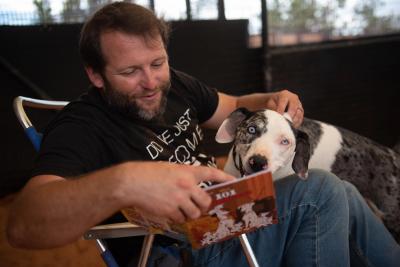 Person reading the "101 Dalmatians" book to Frankie the deaf dog