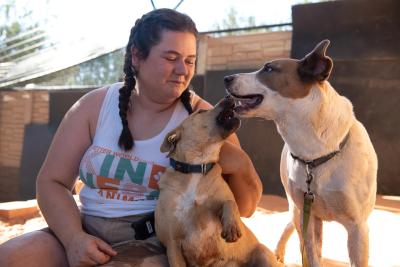 Smiling person interacting with Jules and Lannister the dogs