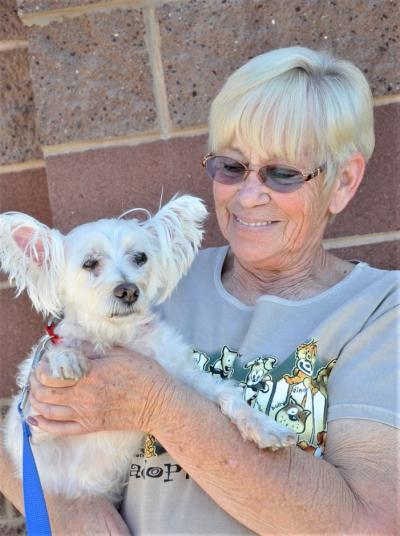 Buddy the dog being held by a smiling woman