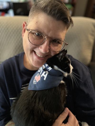 Lisa holding McMuffin the cat, who is wearing a bandanna