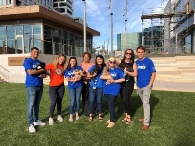 Group of people in front of some buildings holding puppies