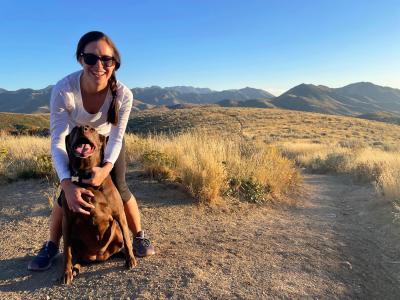 Janelle and Nova the dog in front of some hills