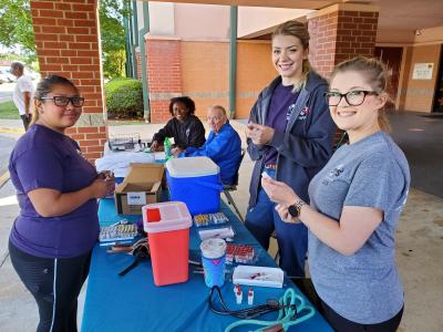 Group of people outside at a table to administer pet vaccinations