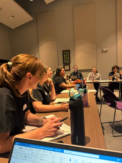 Group of people sitting at tables discussing population rounds