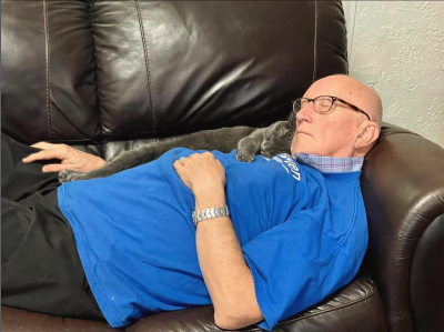 Terry Lauerman sleeping on a couch with a kitten sleeping on his chest