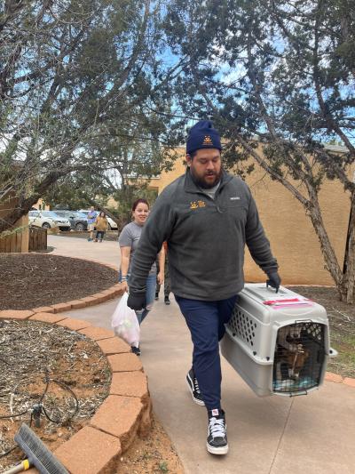 Person carrying a carrier containing a puppy