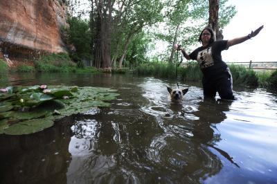 Raquel in a body of water with lily pads and a person whose arms are outstretched