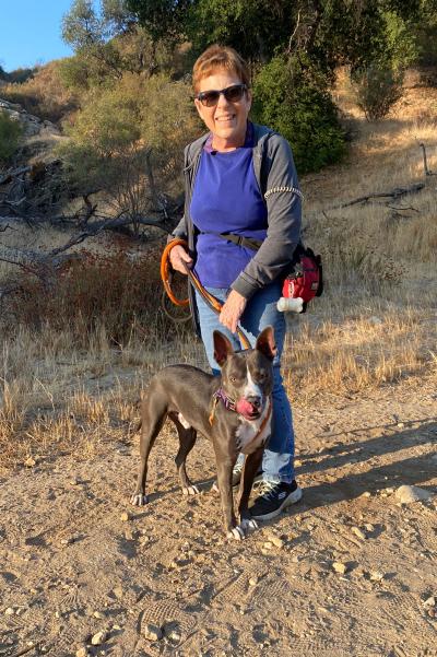 Smiling person walking a dog outside