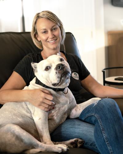 Dog sitting next to a person with his paw in her lap