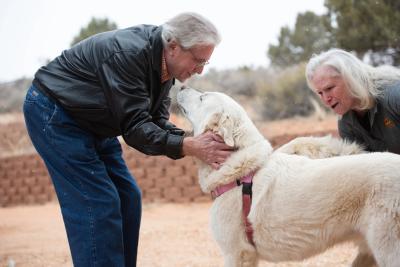 Val and Ty Hardin petting their newly adopted dogs Anna and Racer, outside at the Sanctuary