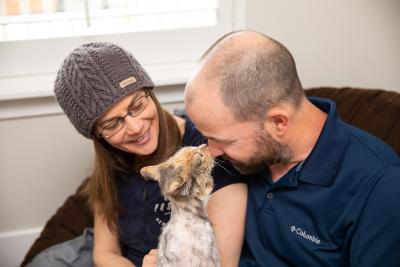 Volunteers Alida and Gary with Cleopatra the cat, who is nose-to-nose with Gary