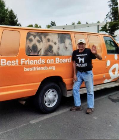 Volunteer Bill Splitter standing next to a Best Friends transport va while waving