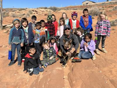 Whitey the dog and J.J. with a bunch of kids from a school