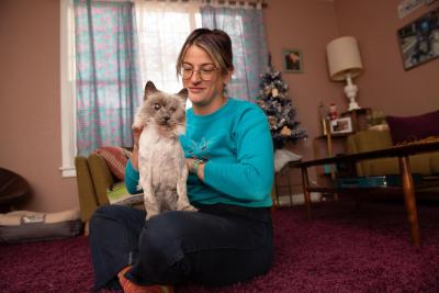 Sylvia the cat sitting on the lap of her foster person Melissa