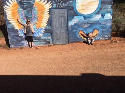 Two members of the Williams family standing in front of murals of wings