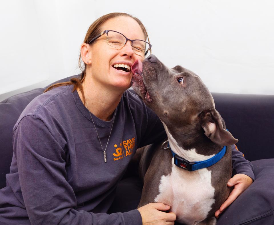 Smiling person sitting next to a dog